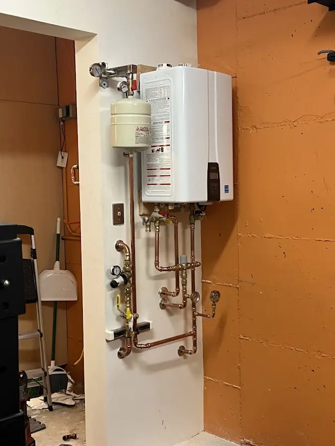 Plumbing technician inspecting water heater connections in Cottleville